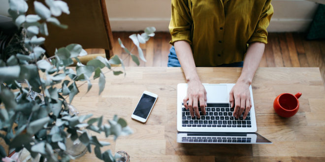 Overhead image of a female blogger writing on the laptop